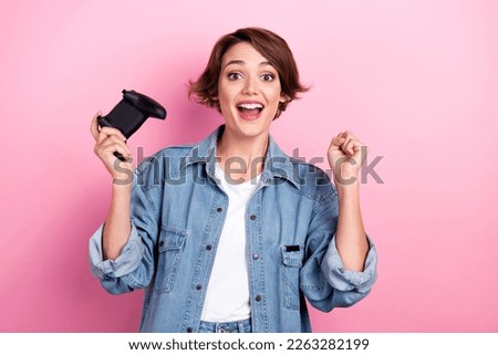 Photo of funky funny lady dressed denim jacket rising fist playing video game isolated pink color background