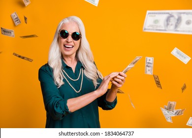 Photo Of Funky Grandma Lady Hold Pack Usa Bucks Money Fall From Sky Wealthy Waste Money Rich Person Wear Green Shirt Sun Specs Necklace Isolated Bright Yellow Color Background