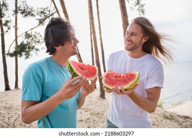 Photo of funky guys eat watermelon wear casual cloth outside on the beach near trees