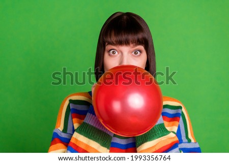 Photo of funky happy nice young woman blow air balloon good mood isolated on green color background