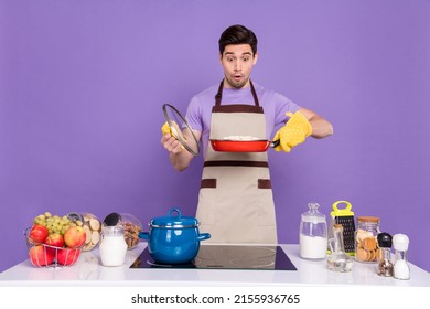 Photo Of Funky Impressed Boyfriend Dressed Chef Outfit Looking Burnt Dinner Isolated Purple Color Background