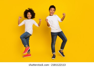 Photo of funky lucky schoolboy schoolgirl wear white shirt rising fists isolated yellow color background - Powered by Shutterstock