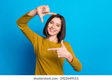 Photo of funky positive woman wear shirt smiling showing arms photo frame empty space isolated blue color background - Powered by Shutterstock