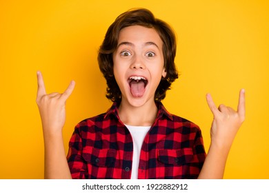 Photo of funky schoolboy tongue out open mouth show horns wear plaid red shirt isolated yellow color background - Powered by Shutterstock