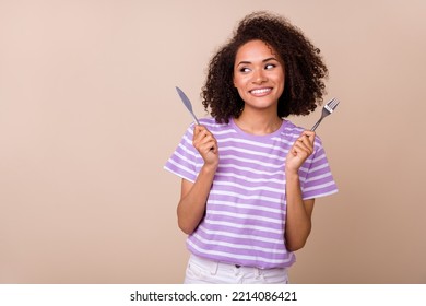 Photo of funky thoughtful lady wear violet t-shirt rising fork knife looking empty space isolated beige color background