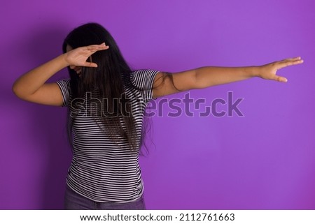Photo of funky young beautiful hispanic woman wearing striped-shirt against purple background show disco move dab