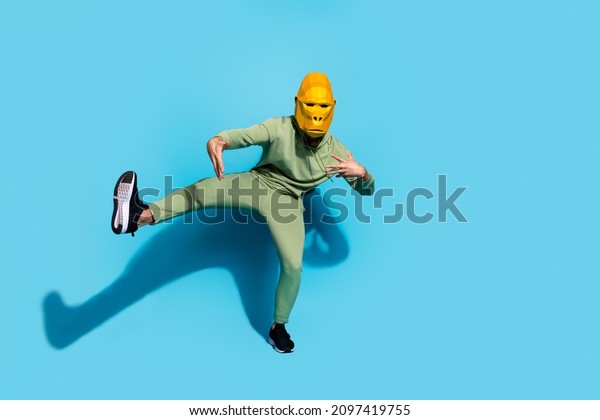 Photo of\
funny carefree crazy guy dance move have fun enjoy event wear\
gorilla mask isolated blue color\
background