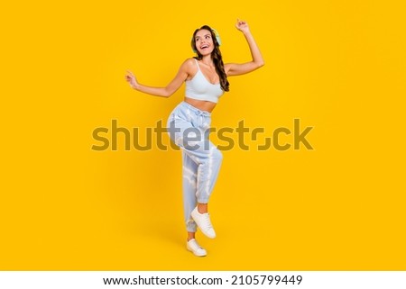 Photo of funny carefree lady enjoy party dance wear headphones sportswear set isolated yellow color background
