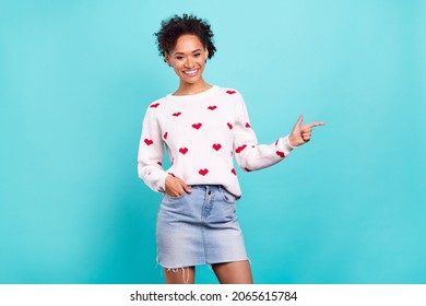 Photo of funny charming african lady dressed white sweater pointing finger empty space smiling isolated blue color background