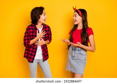 Photo Of Funny Cheerful Kids Talk Look Each Other Laughing Have Good Mood Isolated On Yellow Color Background