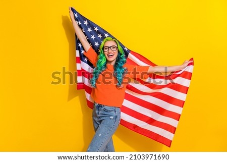 Photo of funny cheerful vibrant woman wear t-shirt spectacles celebrating usa independence day isolated yellow color background