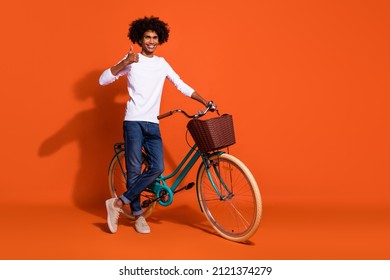 Photo Of Funny Cool Guy Wear White Shirt Thumb Up Driving Cycle Empty Space Isolated Orange Color Background