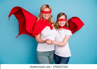 Photo Of Funny Cool Mom Lady Little Daughter Spend Time Together Carnival Super Hero Costumes Hold Arms Cape Flying Wear S-shirts Red Coat Masks Isolated Blue Color Background