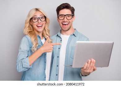Photo of funny couple point laptop wear jeans shirt isolated on grey color background