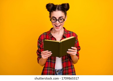 Photo of funny crazy lady hold book read interesting story novel open mouth intrigue moment wear geek vision specs casual checkered shirt isolated yellow color background