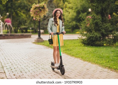 Photo Of Funny Cute Young Woman Dressed Teal Jacket Glasses Cap Riding Kick Scooter Outdoors City Park