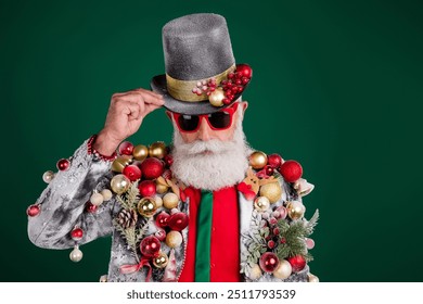 Photo of funny elderly white hair santa man posing wear balls baubles on jacket touch hat isolated on green color background - Powered by Shutterstock