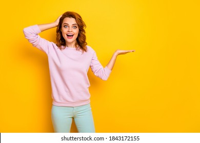 Photo Of Funny Excited Lady Holding Novelty Product On Open Palm Crazy Breaking Sale Low Prices Wear Pink Sweater Green Pants Isolated Yellow Color Background