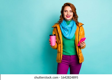 Photo of funny lady hold hot coffee mug beverage browsing telephone walk street wear casual yellow overcoat scarf pants pullover isolated teal color background - Powered by Shutterstock