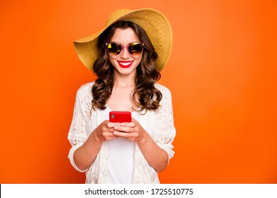 Photo of funny lady summer time holding telephone sending best friend photos from tropical ocean resort wear sun hat specs stylish beach cape isolated orange background - Powered by Shutterstock