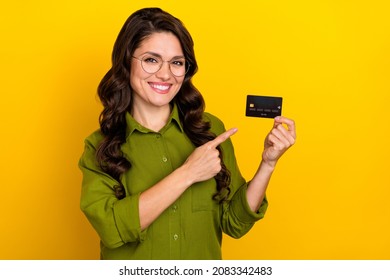 Photo of funny nice lady presenting debit card investment option wear glasses green shirt isolated yellow color background