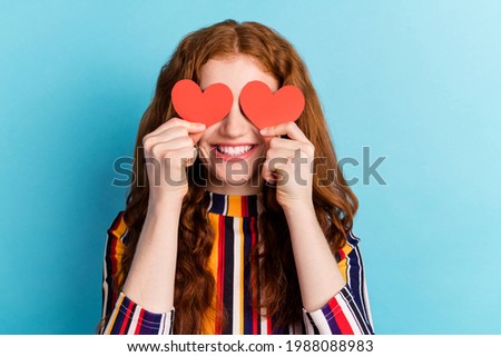 Photo of funny orange hairdo millennial lady hold hearts wear colorful shirt isolated on blue color background