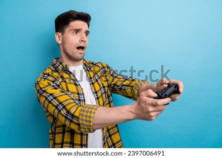 Photo of funny sad guy wear yellow checkered shirt loosing playstation game empty space isolated blue color background