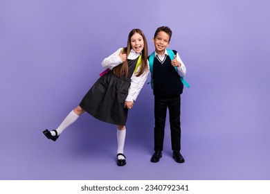 Photo of funny schoolkids enjoy season school discounts make thumb up like isolated bright color background
