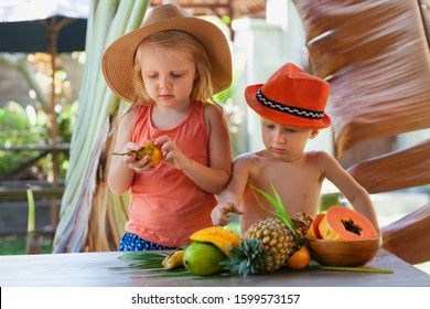 Photo Of Funny Siblings. Couple Of Happy Children With Smiling Face Eating Exotic Tropical Fruits. Healthful Food, Natural Picnic On Luxury Resort. Healthy Lifestyle On Summer Family Holiday With Kids