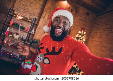 Photo of funny sweet dark skin man wear red sweater holding firework stick tacking selfie smiling indoors room home house - Powered by Shutterstock