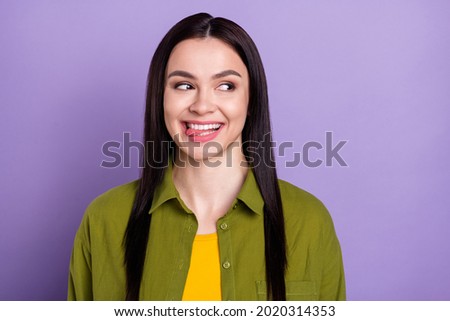 Photo of funny tricky young lady dressed green clothes smiling licking lips looking empty space isolated purple color background