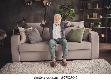 Photo Of Furious Pensioner Wear Grey Cardigan Sitting Couch Holding Remote Trying Find Favorite Tv Show Indoors House Flat