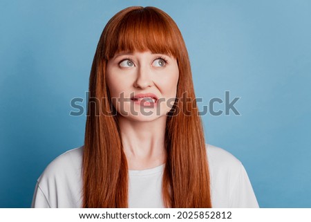Photo of girl bite lip sorry guilty expression think isolated on blue background
