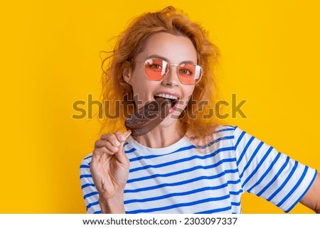 photo of girl eat icelolly ice cream at summer. girl with icelolly ice cream isolated on yellow.