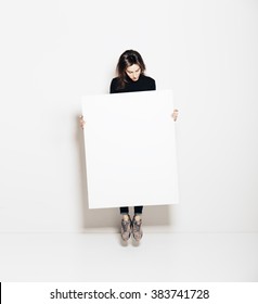 Photo Of Girl Jumping In Modern Gallery And Looking At The Blank White Canvas. Horizontal, Mockup