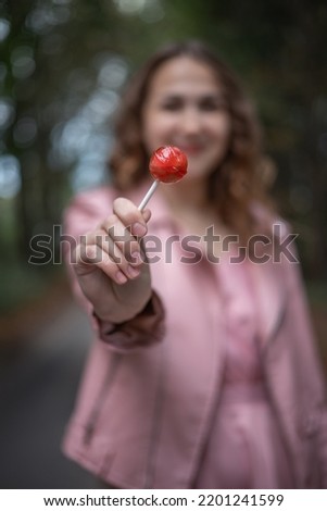 Photo of a girl with a lollipop in her hands.