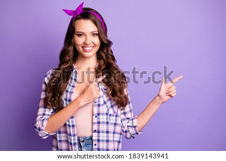 Photo of girl point index finger empty space for ads promotion isolated over purple color background