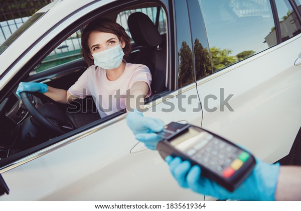 Photo of\
girl travel automobile, ride drive car pay credit bank on gas\
petrol station pos terminal hold steering wheel wear blue latex\
rubber gloves respiratory mask in city\
center