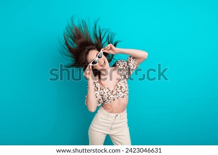 Photo of girlfriend young fashionista touching her gucci sunglasses shaking head flying hair and dance isolated on cyan color background