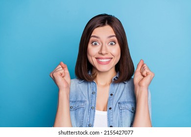 Photo of glad cheerful person raise fists delighted attainment toothy smile isolated on blue color background - Shutterstock ID 2155427077