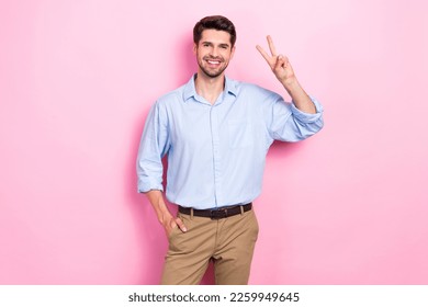 Photo of glad good looking man arm demonstrate v-sign greeting symbol good mood isolated on pink color background
