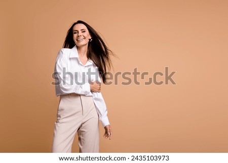 Photo of glamour cheerful lady dressed white shirt enjoying air blowing empty space isolated beige color background