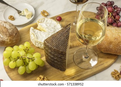 A Photo Of A Glass Of White Wine With Cheese, White And Rye Bread, Red And White Grapes, And Walnuts, At A Wine Pairing. Selective Focus