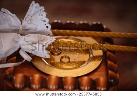 Photo of gold wedding rings closeup. Engagement. Wedding candle with rings. Candles during wedding ceremony in christian church. close up.