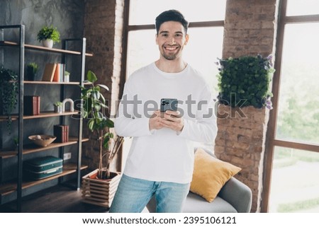 Photo of good mood charming young guy wear white shirt chatting apple iphone samsung modern device indoors apartment room