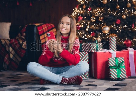 Photo of good mood cute little lady dressed red print pullover ordering apple samsung iphone device x-mas christmas gifts indoors home room