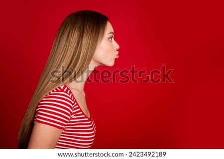Photo of good mood flirty lady dressed striped top sending kiss empty space isolated red color background