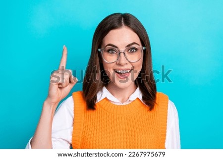 Photo of good mood funny cute clever woman with bob hairstyle orange waistcoat raise finger up good idea isolated on teal color background