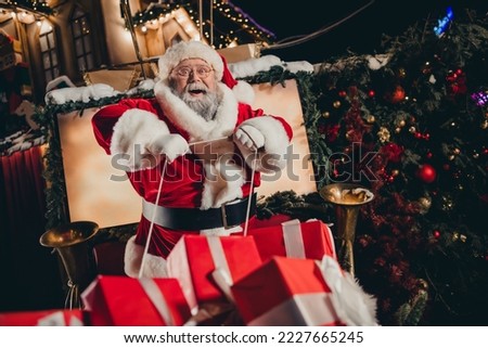 Photo of good personage santa sitting sleigh pulled by reindeer holding rope enjoying travel streets of city carrying miracle outside