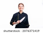 Photo of good-looking female chef stands iand holding a knive smiling at the camera.